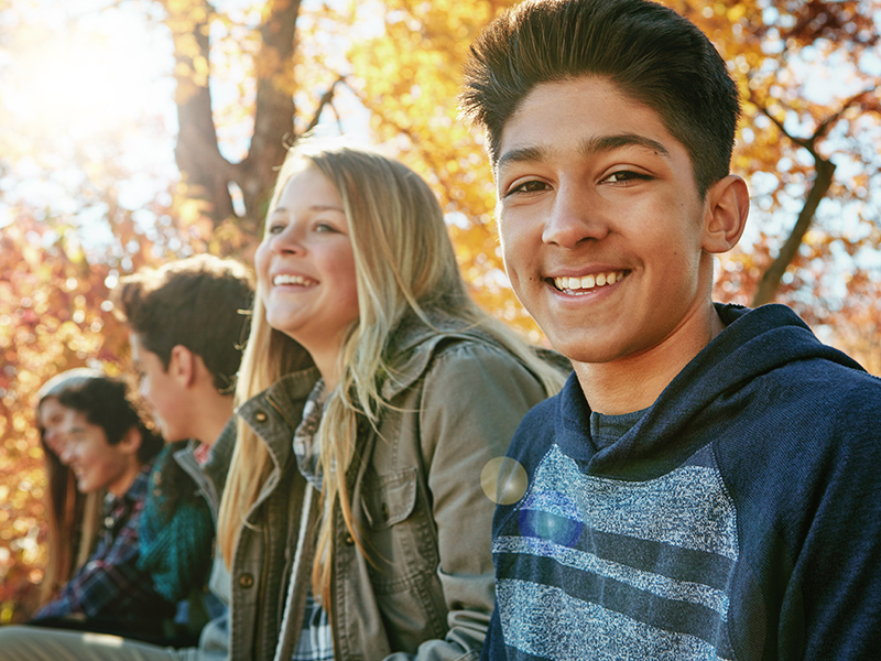 Teenager, friends and portrait in outdoor, boy and diversity on holiday, nature and relax by trees. Youth culture, happy group and gen z school kids in sunshine, woods or park for vacation in Canada